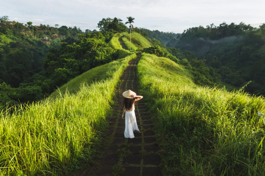 Young beautiful woman walking on Campuhan Ridge way of artists, in Bali, Ubud.
